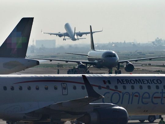 Rephrase the title:Man opens emergency exit and walks on plane’s wing in Mexico airport